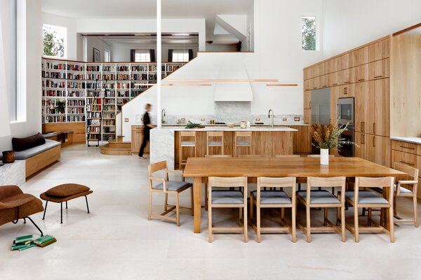 After: The soaring new living and dining space benefits from an abundance of natural light from every side, and they spent a lot of time trying to find the best lighting for the kitchen. The final choice: long, narrow copper pendants from Denmark suspended by ultra thin wires to not disrupt the visual flow of the room.