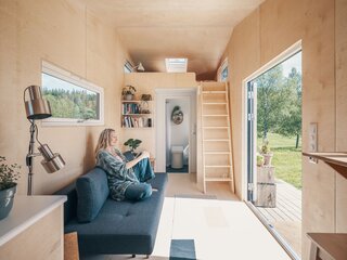 Oiled birch veneer lines the entire interior. Instead of the staircase, a ladder leads up to the loft where a skylight brings more light into the home. Situated on either side of the bathroom entry, closets make up for the storage lost by removing the stair.