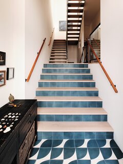 The architects created a proper entry by placing it between the first and second floors, and defining it with Clé tile with a wave motif. A half flight of stairs leads to the second floor, where all of the bedrooms are located.