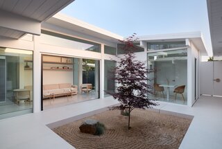 The reading nook corridor has a sizeable sliding glass door that pockets into more glass, with thresholds flush between the cork floors on the interior and the large format porcelain tile on the exterior. The center of the atrium is filled with raked 1/8” Desert Gold crushed granite.