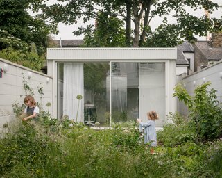 The side walls have been treated as vertical extension of the horizontal surface of the garden, and are used for growing climbers such as jasmine, grapes, honeysuckle, raspberries, beans, peas, and even a climbing fig. Colorful bird’s houses and bug hotels are also mounted on the walls.