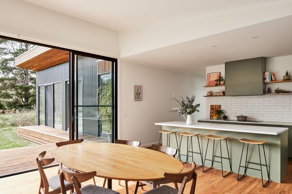 A simple kitchen gives way to a vintage dining table, one of many pieces Zara and James found online. Sliding glass doors help bring the outside in.