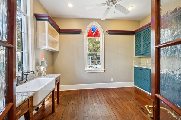 Arched Brazilian cherry doors open to a spacious laundry room/pantry set near the kitchen.