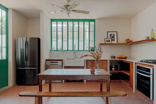 Mint green-painted ironwork and tiles connect the indoors to the outside more fluidly.