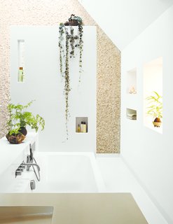 Amending Meeuwissen’s early request for an open bathroom space, the architects devised a more private chamber with an overhead skylight and walls in stone tile from Intercodam Tegels.