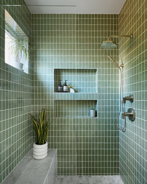 Olive-green Fireclay tile creates a spa-like experience in the bathroom and fluctuates in tone throughout the day.