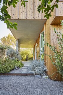 On the home's east side, the overhang created by the second story volume shades the front door while still allowing morning light into the bedrooms.