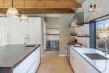 The kitchen is fitted with a prep pantry, Italian cabinetry, and a leathered quartzite island.