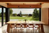 Every room in the home enjoys views of the landscape—including the dining area. The natural material palette of the interior emphasizes this connection between inside and out.