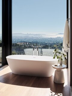 The bathroom features a stunning floor-to-ceiling window.