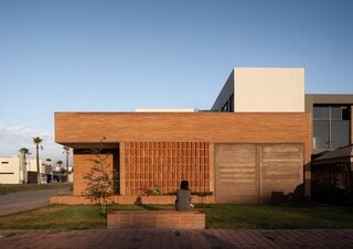 The brick-and-glass residence accommodates limited mobility with a lift between levels and seamless thresholds between indoors and out.
