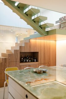 Their carpenter Proedl built a lot of the storage and furniture in the apartment, including these concealed cubbies beneath the stairs—with room for a dry bar, of course.